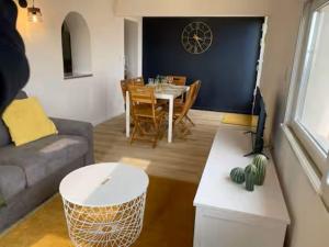 ein Wohnzimmer mit einem Sofa und einem Esstisch in der Unterkunft T3 with large roof-top terrace, harbor view in Gruissan