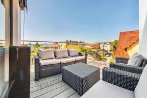 a patio with two chairs and a couch on a balcony at Hel Żeromskiego, Sun & Snow in Hel