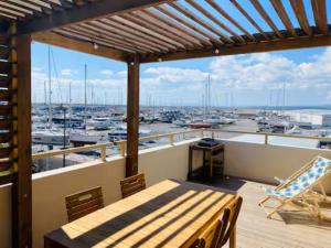 einen Balkon mit einem Tisch und Hafenblick in der Unterkunft T3 with large roof-top terrace, harbor view in Gruissan