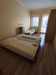 a bedroom with two beds and a wooden floor at Apartmány ORAVA-EDDA in Martinske Hole