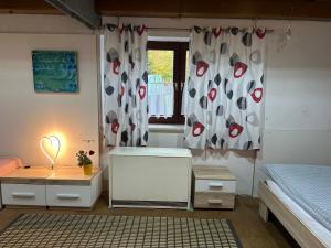 a bedroom with a bed and a desk and a window at TONIS Room - WPA Apartments in Moosthenning +2 photos