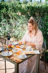 a woman sitting at a table with food on it at Casale Oliveta in Orbetello +20 photos