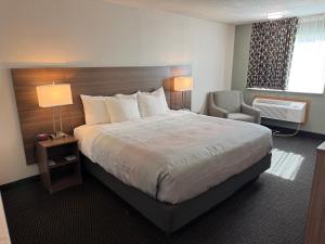 a hotel room with a large bed and a chair at Quality Inn By Choice Hotels - West Des Moines - I 235 & I 80 in West Des Moines