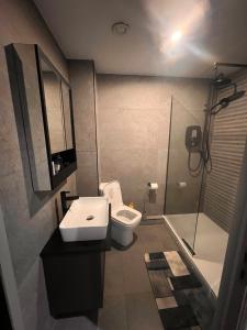 a bathroom with a sink and a toilet and a shower at The Jesmond Hideaway - Cosy Modern Apartment in Jesmond