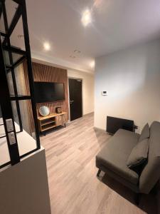 a living room with a couch and a flat screen tv at The Jesmond Hideaway - Cosy Modern Apartment in Jesmond +12 photos