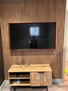 a television on a wooden wall with a wooden table at The Jesmond Hideaway - Cosy Modern Apartment in Jesmond