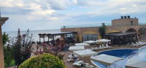 a resort with a pool and tables and chairs at Studio F210 - Bulharsko in Aheloy