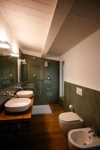 a bathroom with three sinks and two toilets at Radicata Tuscany Relais in Albinia