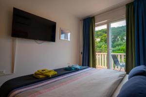 a bedroom with a bed with a television and a balcony at Apartments Viva in Korčula