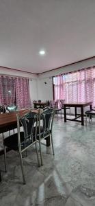 a dining room with tables and chairs and windows at Hotel Thangshing In in Lachung