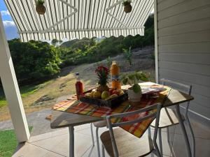 een tafel met een fruitmand op een veranda bij Bungalow confortable à Le Gosier - 20 m² avec jardin in Mare Gaillard +30 foto's