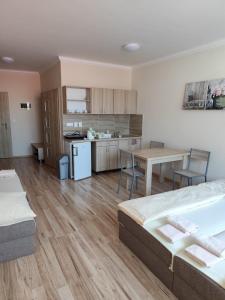 Habitación con 2 camas, mesa y cocina. en Apartmány ORAVA-EDDA, en Trenčianske Teplice