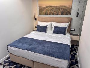 ModričaにあるHotel Modričaの青い枕が付いた大きなベッドのある寝室