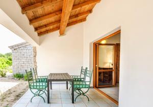 a patio with a wooden table and chairs at ISA - Residence with swimming pool in Badesi just 300 mt from the sea in Badesi +9 photos