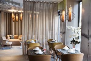 a dining room with tables and chairs and a couch at Hôtel Eiffel Segur in Paris