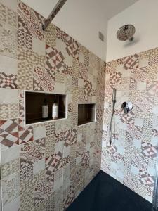 a bathroom with a shower with a tiled wall at L'obiettivo in Assemini