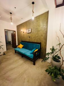 a blue couch in a room with a wall at MUSA Holiday Inn in Dodanduwa