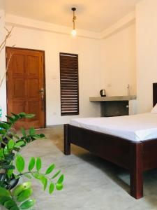 a bedroom with a bed and a wooden door at MUSA Holiday Inn in Dodanduwa