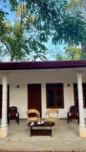 a patio with chairs and a table in front of a house at Sigiri Sihina Villa in Inamaluwa