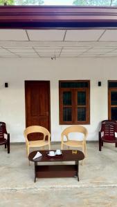 a living room with a coffee table and chairs at Sigiri Sihina Villa in Inamaluwa +1 photo