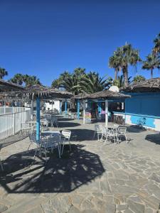 a group of chairs and tables with umbrellas at Casa Camila in Corralejo +30 photos