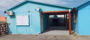 a blue house with an open door at Francas del Este in San Antonio Oeste