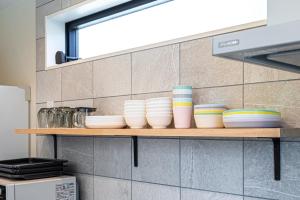 a shelf in a kitchen with bowls on it at 海まで徒歩7分庭とデッキでくつろぐ大人葉山の上質ステイ in Hayama