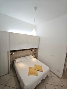 a small bedroom with a white bed with a gold object on it at Domenico 's in Ruvo di Puglia +6 photos