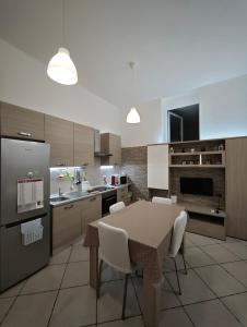 a kitchen with a table and white chairs in it at Domenico 's in Ruvo di Puglia