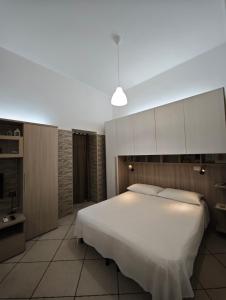 a bedroom with a large white bed and cabinets at Domenico 's in Ruvo di Puglia