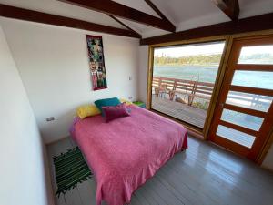 Dormitorio con cama y vistas al agua en Refugio Guanay, en Constitución