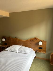 Un dormitorio con una cama con cabecero de madera. en Hotel le Chasseur, en Illkirch-Graffenstaden