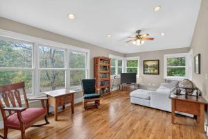 a living room with a couch and chairs and windows at Secluded Woodland Retreat Near Starved Rock Park home in Grand Ridge