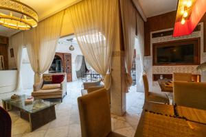 a living room with curtains and a table and chairs at Riad Dar Salima - Locanda Boutique Collection in Marrakech