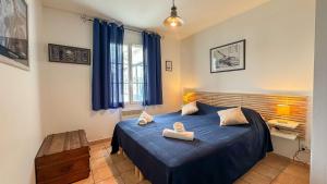a bedroom with a blue bed with two towels on it at Charmante location de plain-pied proche plage in La Couarde-sur-Mer