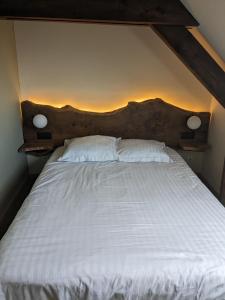 a bed with white sheets and two pillows at Hotel le Chasseur in Illkirch-Graffenstaden +3 photos