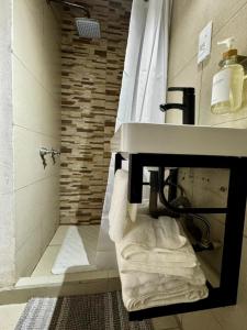 La salle de bains est pourvue d'un lavabo, d'une douche et de serviettes. dans l'établissement Departamento moderno cerca del Estadio de Béisbol Toluca, à Toluca