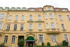 ein großes gelbes Gebäude mit einem Schild drauf in der Unterkunft Hotel Viktoria Schönbrunn in Wien