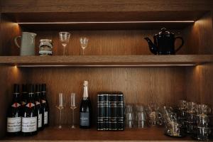 ein Regal mit Weinflaschen und Gläsern darauf in der Unterkunft Bryggjan Boutique Hotel in Akureyri + 6 Fotos