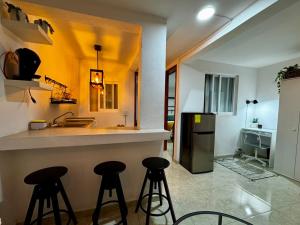 une cuisine avec deux tabourets de bar et un comptoir dans l'établissement Departamento moderno cerca del Estadio de Béisbol Toluca, à Toluca