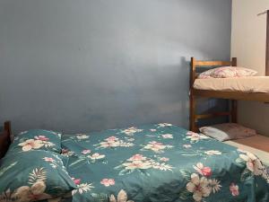 a bedroom with a bed with a green blanket with flowers at Mare Azzurro Praia do Itagua in Ubatuba