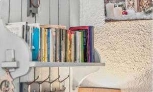 a shelf filled with books on a wall at au Bonheur - Praloup 1600 - Au cœur de la station et au pied des pistes - La voile des neiges - parking commun privé - local ski in Pra-Loup