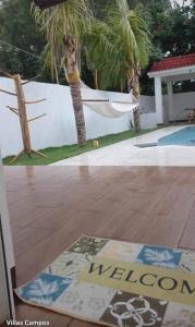 een veranda met een hangmat en twee palmbomen bij Villas Campos Monterrico in El Banco