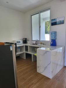 een keuken met marmeren aanrechtbladen en een wastafel bij Villas Campos Monterrico in El Banco