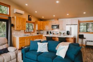 a living room with a blue couch and a kitchen at Sequim Bay Hideaway in Sequim