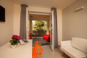 a living room with a couch and a table and chairs at Holiday Apartments - Camping Al Porto in Nago-Torbole