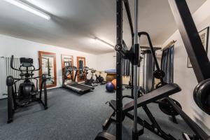 a gym with several treadmills and weights at Hotel Evaldo in Arabba