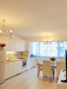a kitchen with white cabinets and a table with chairs at Apartment Elizabeth with balcony in Split +27 photos