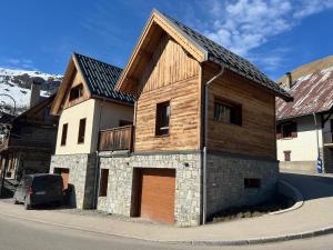 a wooden building with a garage on the side of a street at Chalet Saint Sorlin in Saint-Sorlin-dʼArves