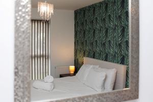a bedroom with a bed with white pillows and a mirror at Autumn Heights Apartments in Telford